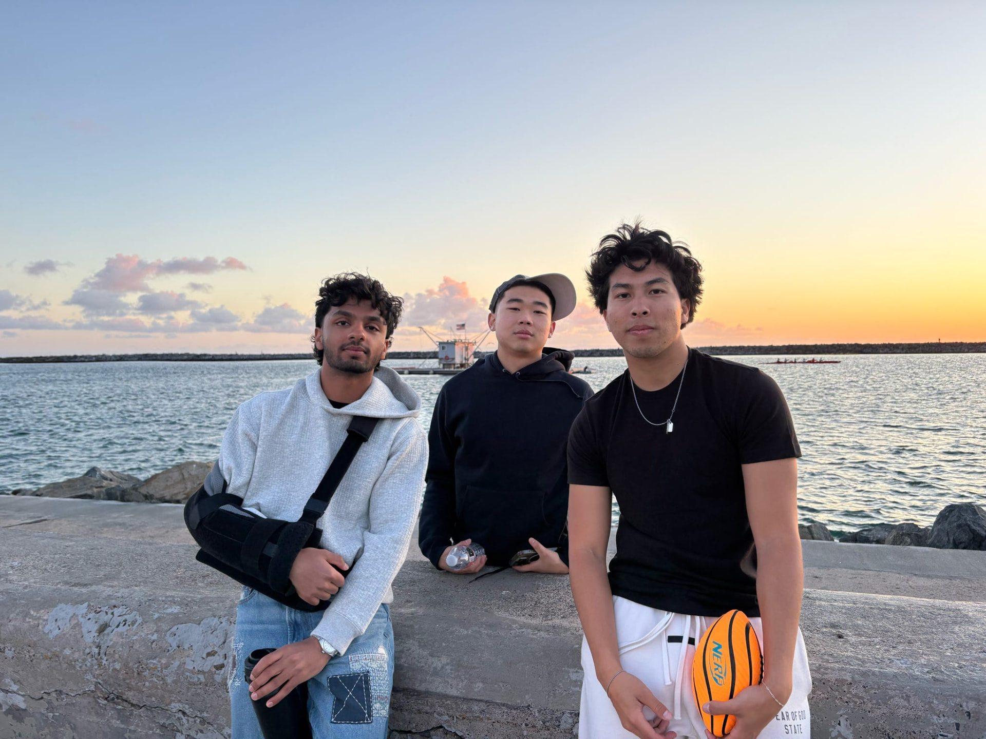 Chapter brothers together by the waterfront at sunset