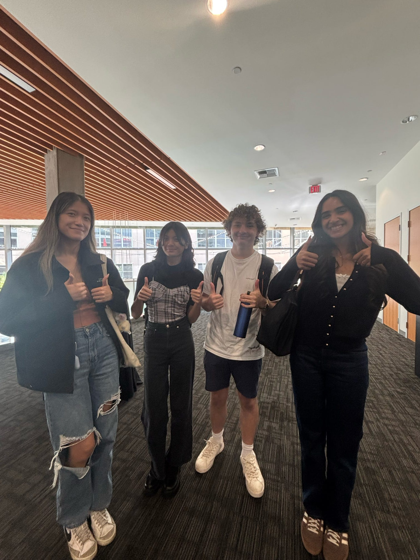 Four chapter members giving thumbs up after an event