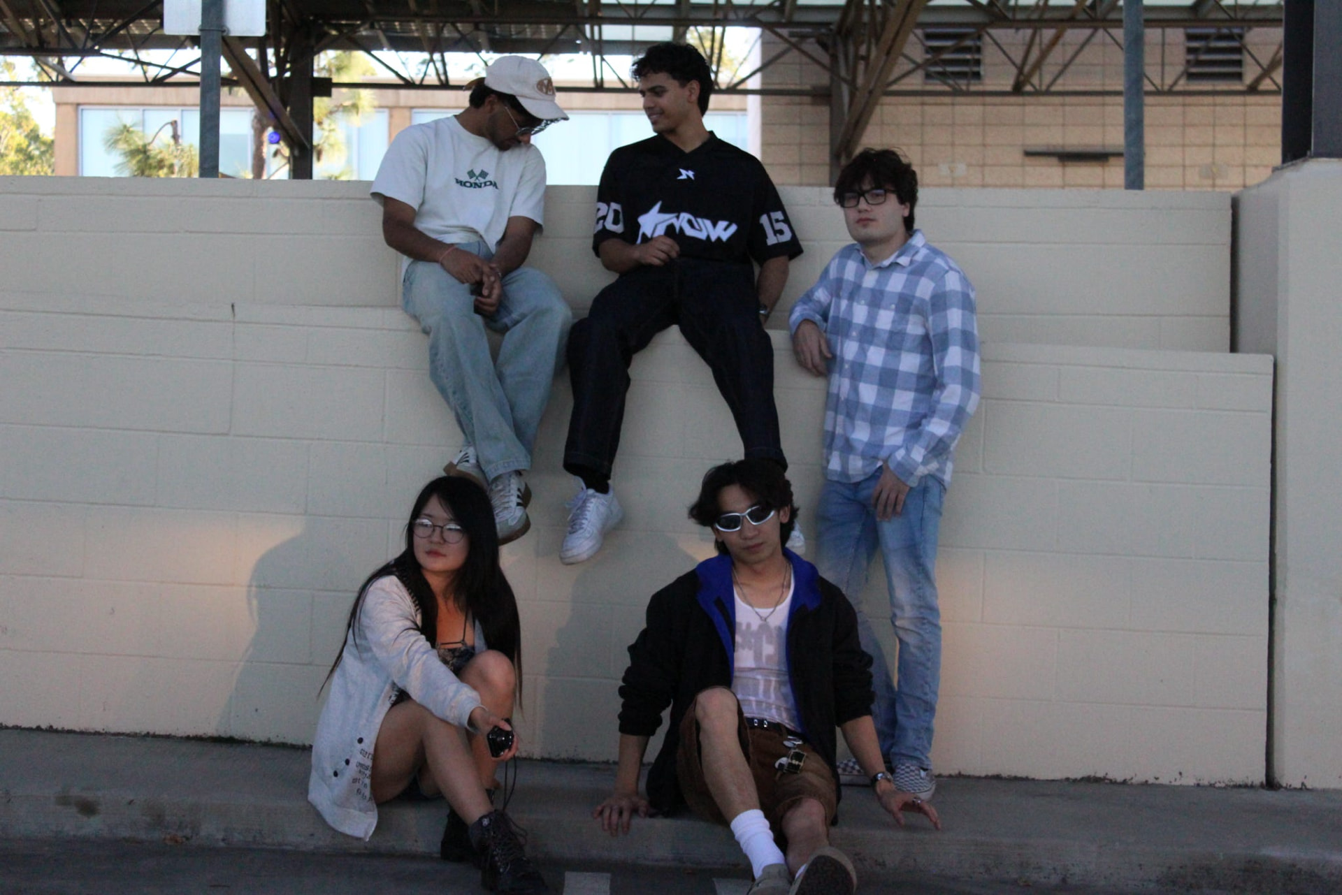 Five chapter members hanging out on a wall at sunset